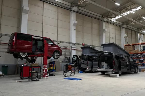 Dilovası üretim tesisinde lifte alınmış VW Transporter ve dönüşümü süren iki Ford Transit Custom