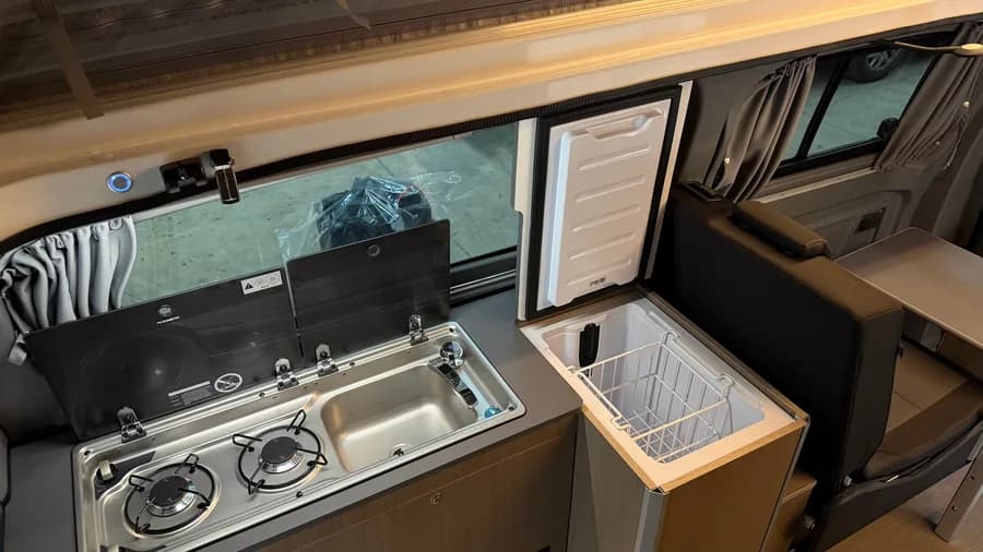 Kitchen detail with the Dometic hob and sink and the open Indel B compressor fridge