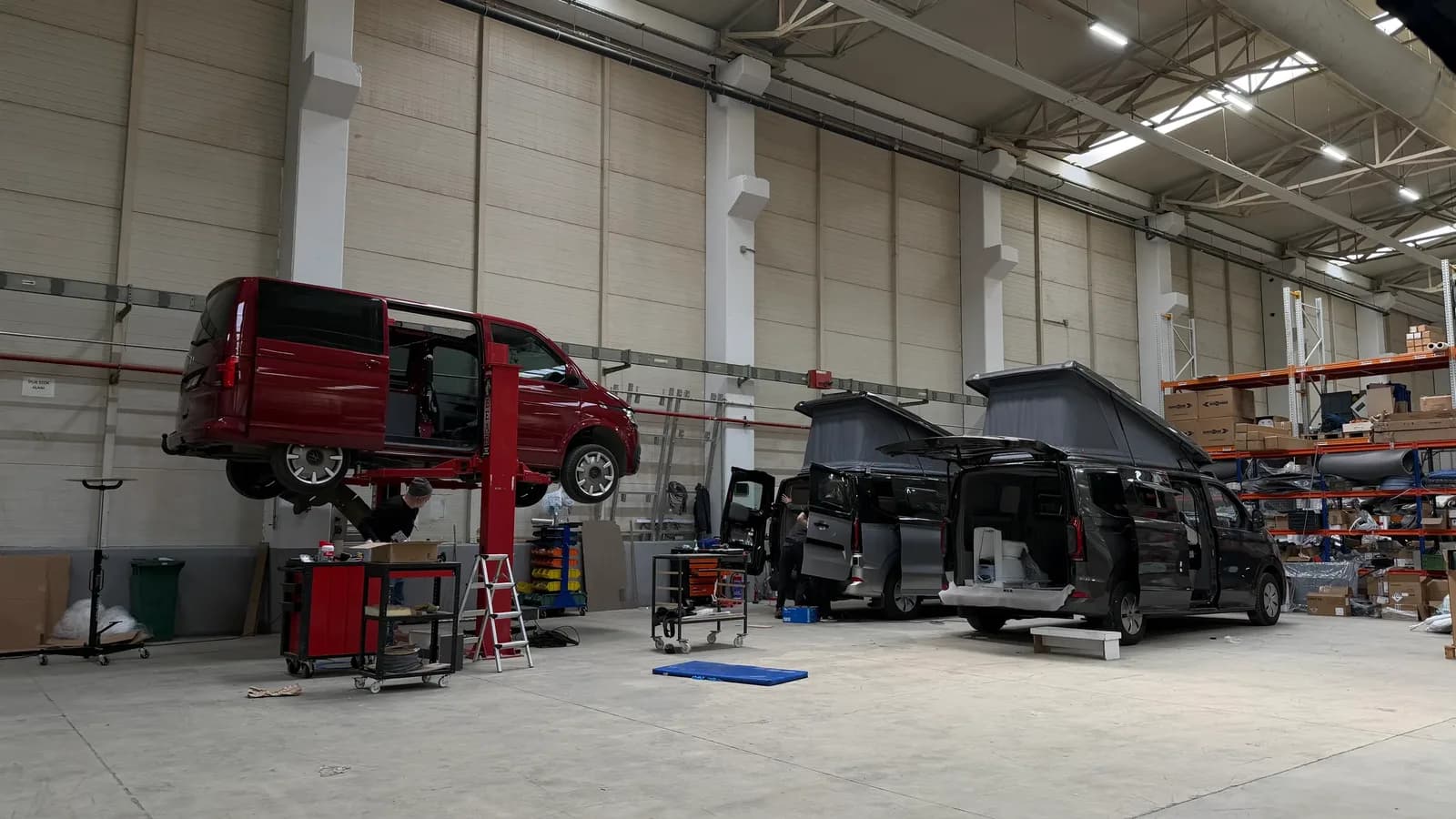 Dilovası üretim tesisinde lifte alınmış VW Transporter ve dönüşümü süren iki Ford Transit Custom