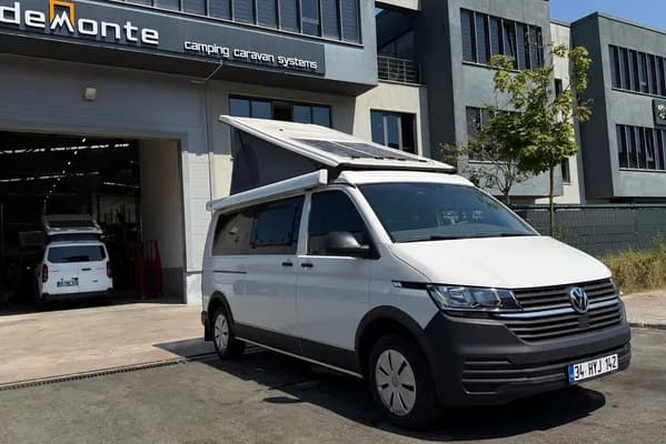 White VW Transporter Efes outside the Demonte Caravan facility with the SCA reverse-lift roof and solar panel