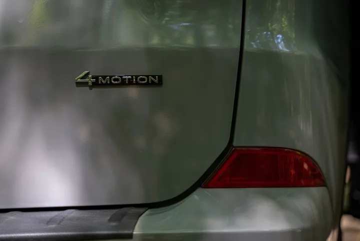 Nahaufnahme des 4MOTION-Emblems auf der grünen Karosserie neben der Rückleuchte