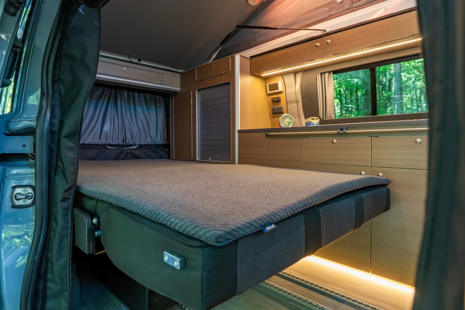 Das ausgeklappte 130 × 190 cm Unterbett mit Schrankzeile und indirekter LED-Beleuchtung